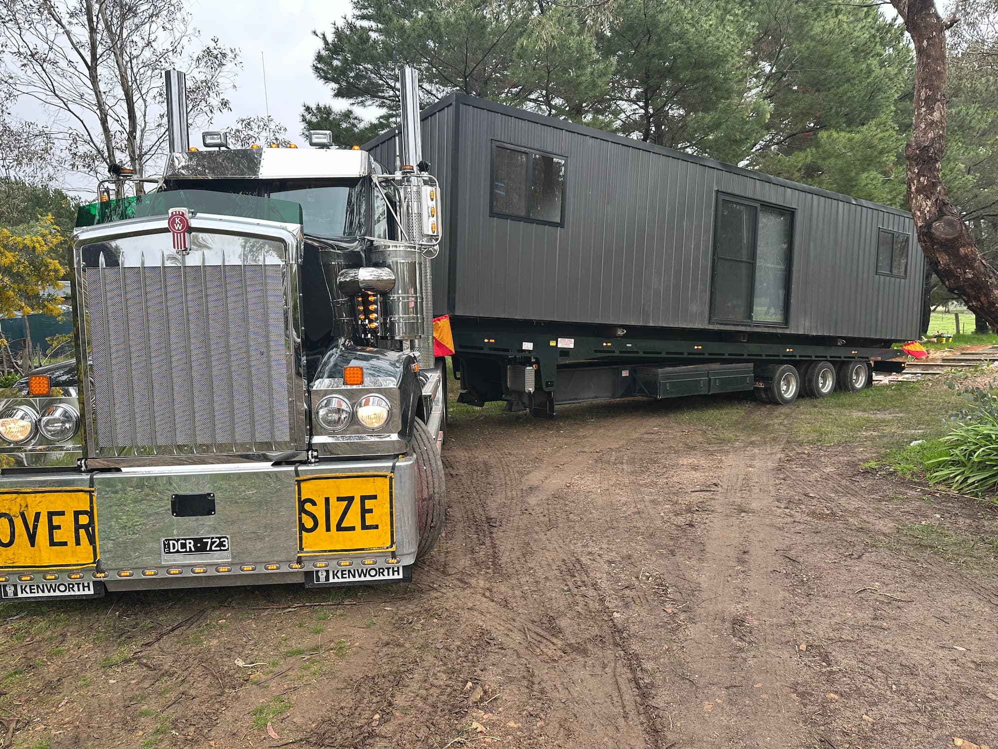 ALL TOW Kenworth towing portable building Melbourne Kenworth tilt tray truck transporting portable building
