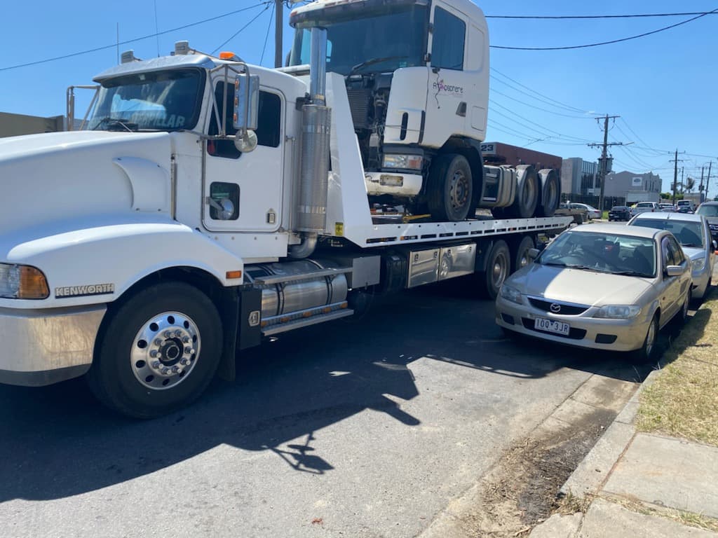 White Kenworth heavy tilt tray towing truck on flatbed in Melbourne