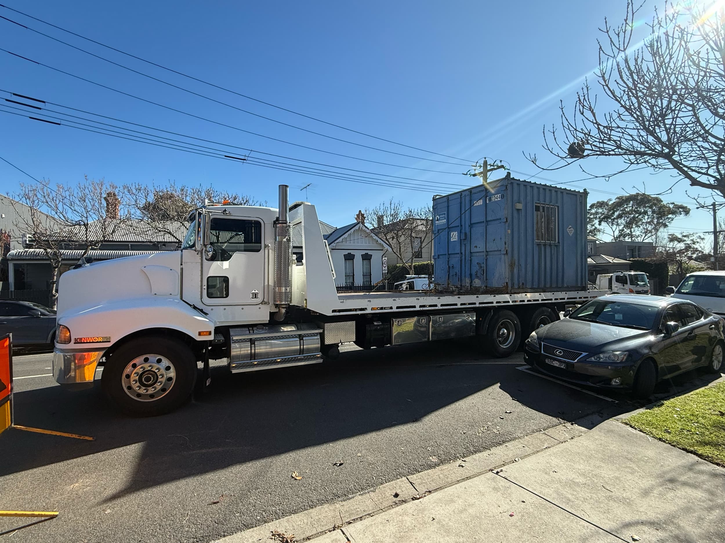 Kenworth tilt tray truck transporting shipping container Melbourne