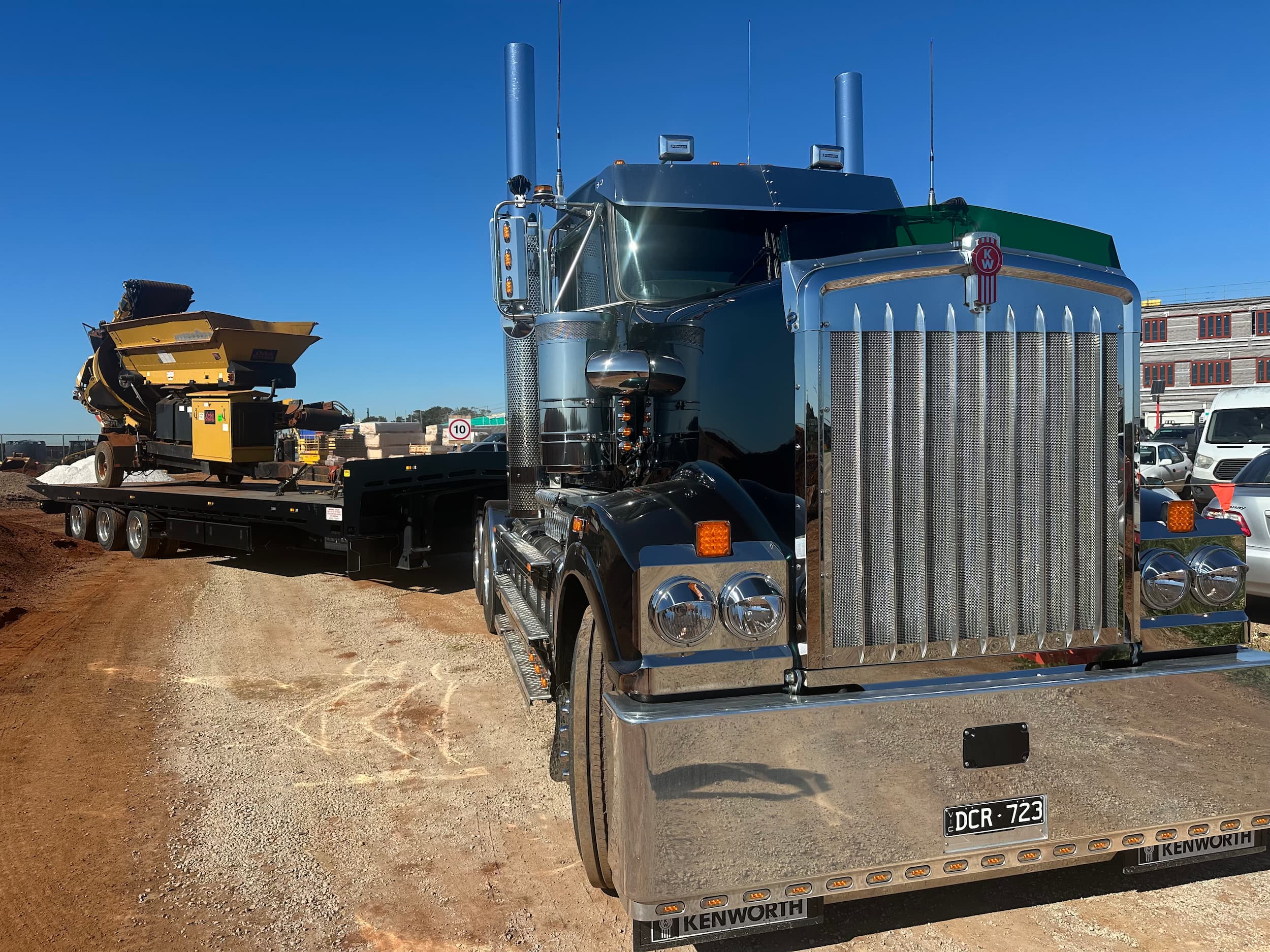 ALL TOW Kenworth tilt tray transporting heavy site conveyor