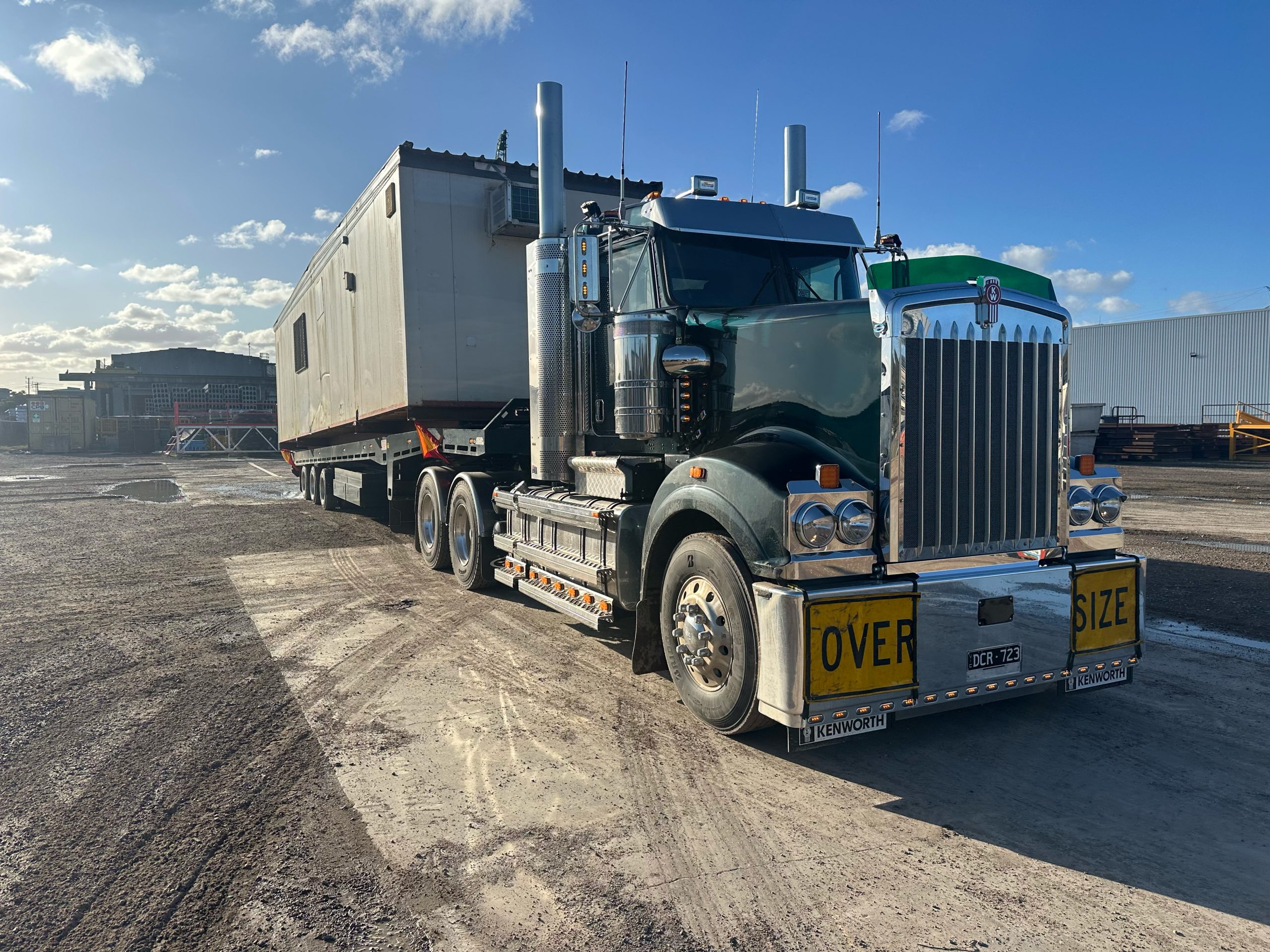 Kenworth truck transporting portable building on heavy tilt tray in Melbourne